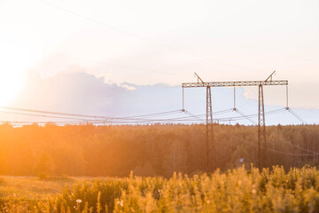 Power transmission lines (power lines) on steel supports against the background of the evening...