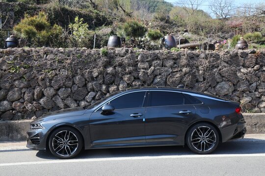 HWAGAE-MYEON, SOUTH KOREA - APRIL 2, 2023: Kia Optima car also known as Kia K5, Korean mid-size sedan car parked along rural road.