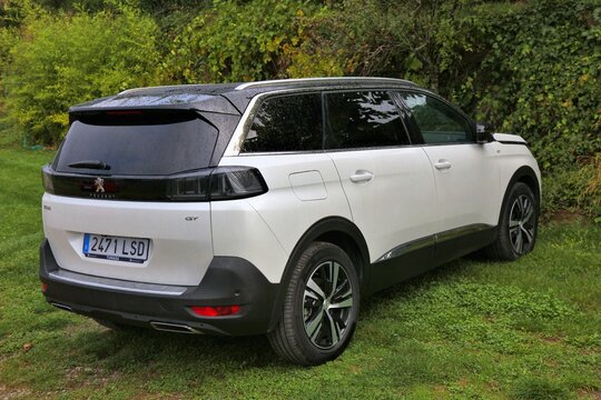 HUESCA, SPAIN - SEPTEMBER 25, 2021: Peugeot 5008 family SUV parked off road on grass in Spain.