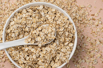 Dry uncooked oat flakes in a spoon top view