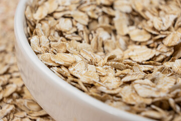 Dry uncooked oat flakes in a plate