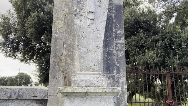 Mammalocchi statue travertine column with allegorical figures standing at entrance to private villa in Umbria, Italy. Tilt-up