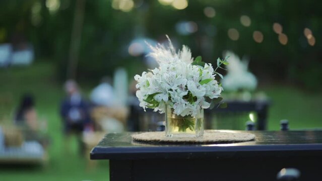 Glass vase with astromelias Peruvian lily and pampas grass flowers. Wedding decoration details.