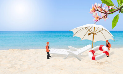 Two miniature worker carry beach item on tropical beach, outdoor day light, it's summer time