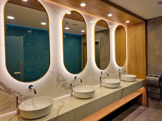 Contemporary interior of public toilet with sinks and mirrors