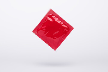 red condom motion floating in the air isolated on a gray background, protection, contraceptive and...