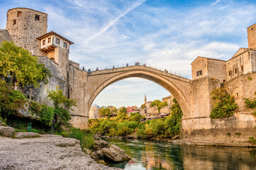 Historical Mostar Bridge known also as Stari Most or Old Bridge in Mostar, Bosnia and Herzegovina. Skyline of Mostar houses and minarets, at the sunset in Bosnia and Herzegovina.