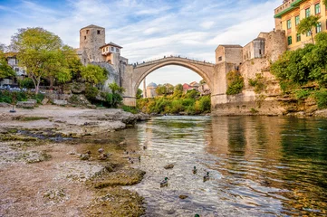 Photo sur Plexiglas Stari Most Historical Mostar Bridge known also as Stari Most or Old Bridge in Mostar, Bosnia and Herzegovina. Skyline of Mostar houses and minarets, at the sunset in Bosnia and Herzegovina.