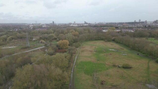 Pedestal drone shot showing a marshy field and the town of Leicester Riverside in the background located in a countryside in United Kingdom.