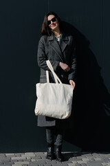 White tote bag or eco cotton bag in woman's hand