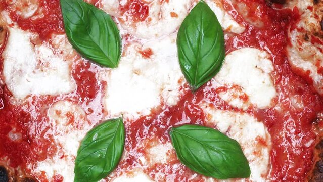 Pizza Margherita with mozzarella cheese,tomatoes and fresh basil.Switch between close-up and top view with fast zoom out.Delicious Neapolitan Pizza Margherita.italian food.Restaurant Pizza Food.Italy