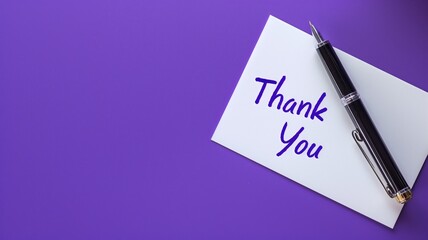 Thank you card with a black pen on purple background.