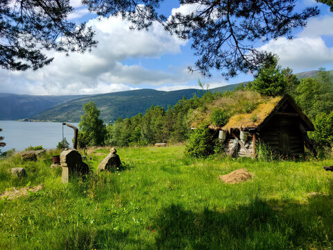 old, typical mountain hut, overgrown with moss by the lake in the mountains of Norway