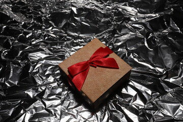 Gift box with a bow on a silver background. Beautiful background for photos. Jewelry box with red...