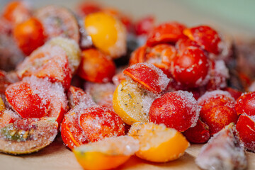 Close-up of frost-covered, sliced tomatoes revealing their icy textures and vivid red coloration.