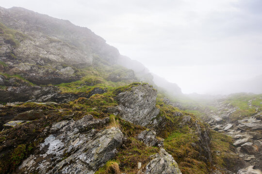 romanian countryside scenery on a foggy day. mountainous nature landscape with steep rocky hills. extreme summer vacations in fagaras