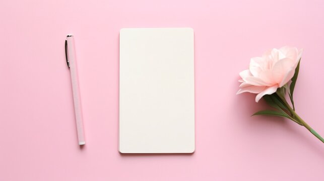 a notebook and pen on a pink surface
