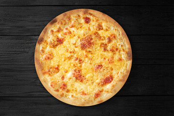 Pizza four cheese on black wooden background top view
