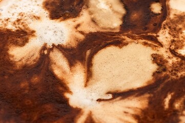 The image shows a coffee with an abstract design in its foam, creating an intriguing visual contrast that invites contemplation.