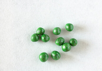 Close-up of broccoli cabbage seeds in green dragee shell. Modern way to protect seeds from pests and stimulate seedling germination. Growing organic vegetables concept. Flat lay, macro, top view