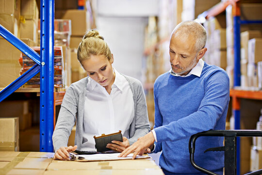 Tablet, clipboard and business people in distribution facility for logistics, supply chain and cardboard box. Package, ecommerce and employees with technology for shipping, cargo and stock taking