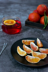 Blood oranges in wooden box or black plate