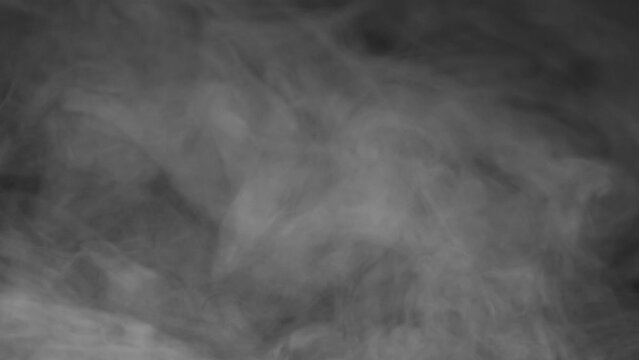Hanging Smoke Quickly Disappears. Smoke moves slowly on a black background and a sharp stream of air blows it away leaving blackness