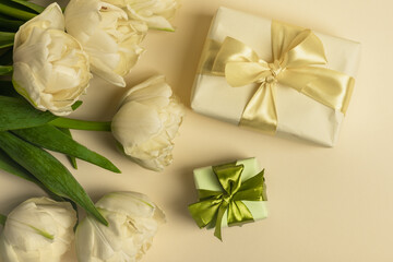 Bouquet of  yellow tulips and yellow gift box on a yellow background. Concept for congratulations on Women's Day, Mother's Day, Birthday and Valentine's Day.