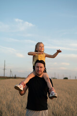 Daughter sits on her father's shoulders	