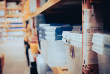 Toned photo hardware store aisle with full stack of transparent boxes, latching storage container,...