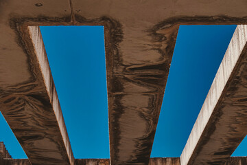 background with concrete beams against the blue sky - obrazy, fototapety, plakaty