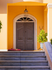 A classic design house entrance with an arched wooden door at posh suburbs of Athens. Travel in Greece.
