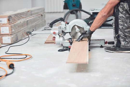 Professional handyman installing laminate flooring in a new apartment.