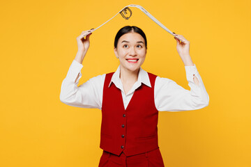 Young lawyer employee business woman of Asian ethnicity wear red vest shirt work hold folder papers document bookkeeping above head pov roof isolated on plain yellow background. Office career concept.