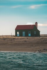 Quaint red cabin on the shoreline overlooking the tranquil waters