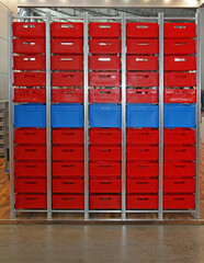 Large Storage Tower Shelf With Red Plastic Crates in Warehouse
