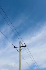 Low-angle vertical shot of Wire poles under the blue sky