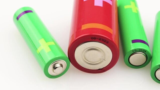 Closeup video of batteries in different sizes and colors on a white background