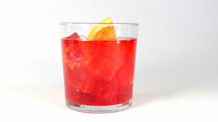 Close-up shot of an orange-garnished red beverage