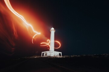 Idyllic scene of a lighthouse in Japan illuminated by light painting at night