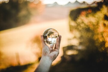 Person's hand holding a glass ball