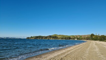 Tranquil sandy beach with soft waves on a sunny day
