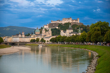 Fototapeta na wymiar Salzburg, Austria, August 15, 2022. Golden hour shot towards the historic center. Highlighted is the fort at the top of the hill which dominates the landscape.