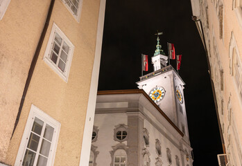 Salzburg, Austria, August 15, 2022. Fascinating night shot of the town hall clock tower. The red...