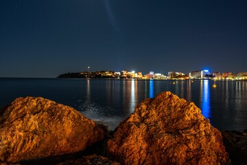 Scenic shot of a city skyline reflected in the tranquil waters of the sea in Mallorca, Spain