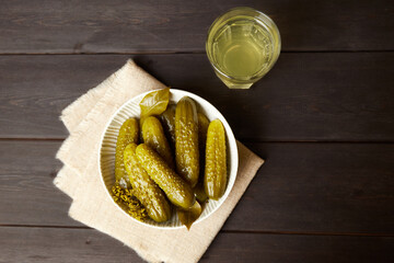 Marinated cucumbers and pickled juice on a dark wooden background. Homemade pickles. Top view.