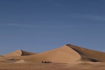 Fototapeta na wymiar a few people are riding horses through a desert landscapes