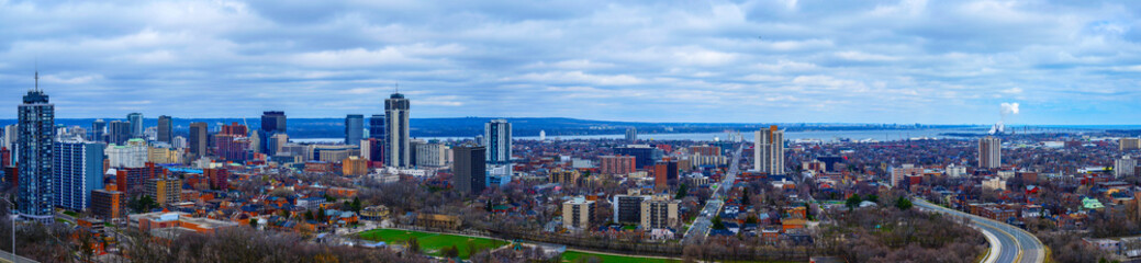 Hamilton Ontario city skyline, downtown buildings, horizon, and the Lake Ontario in the distance in...