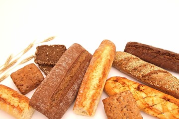 Several different kinds of bread are lined up together on a table.