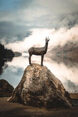 Goldenhorn statue proudly standing against the scenic Bohinj Lake in Slovenia
